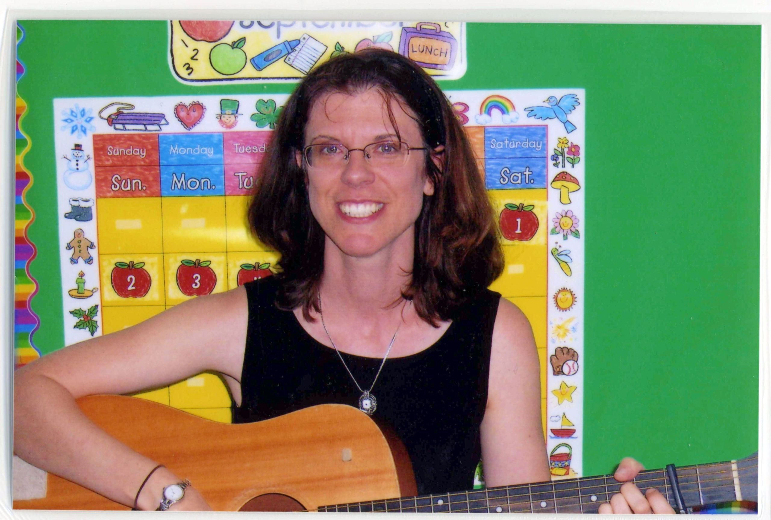 Margie playing guitar in a classroom setting